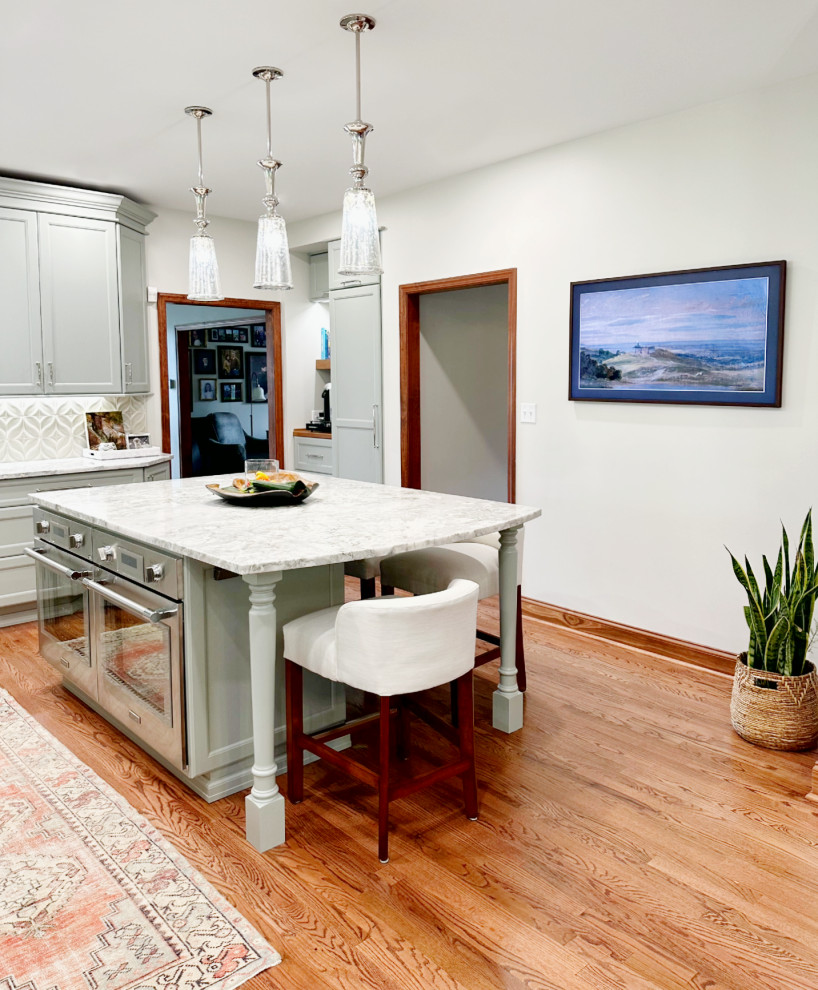 Eat-in kitchen - transitional l-shaped medium tone wood floor eat-in kitchen idea with shaker cabinets, green cabinets, quartzite countertops, porcelain backsplash, paneled appliances and an island