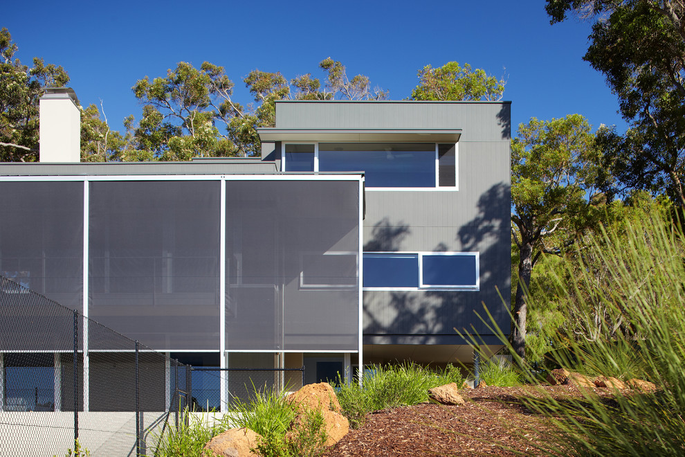 Inspiration for a mid-sized contemporary two-storey exterior in Perth with concrete fiberboard siding and a flat roof.