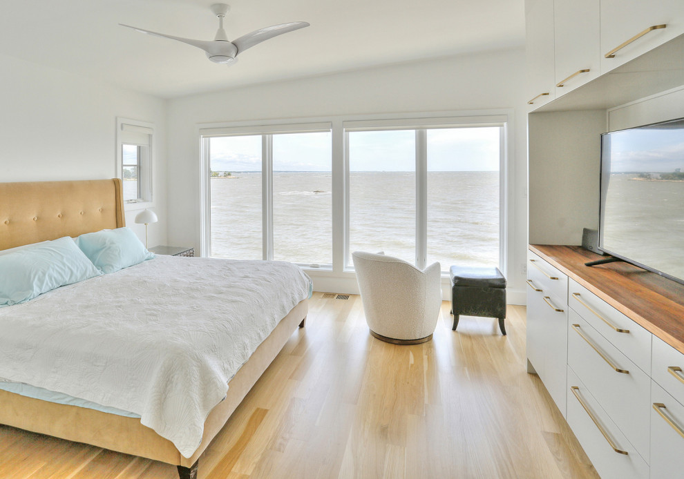 Mittelgroßes Skandinavisches Hauptschlafzimmer ohne Kamin mit weißer Wandfarbe, hellem Holzboden, beigem Boden und gewölbter Decke in Bridgeport