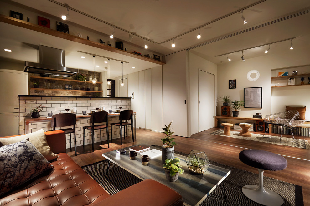 This is an example of a contemporary open concept living room in Tokyo with white walls and medium hardwood floors.