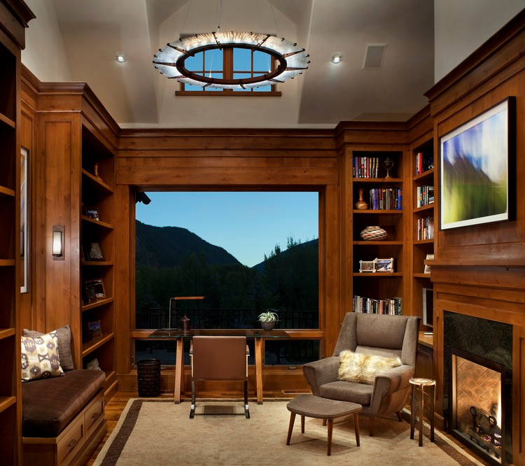 Example of a mid-sized trendy freestanding desk medium tone wood floor study room design in Denver with a standard fireplace