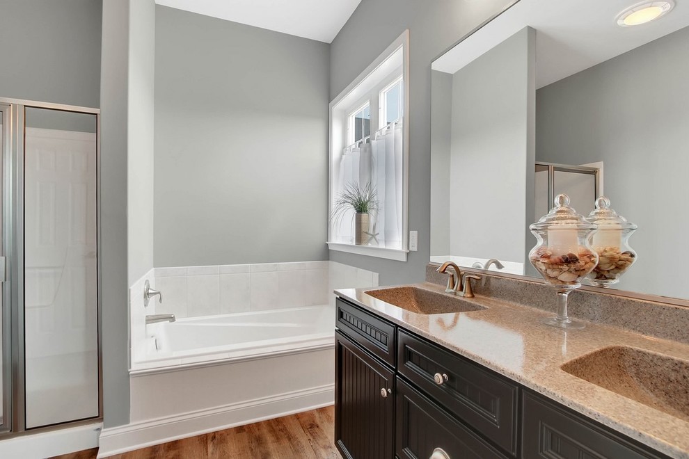 Design ideas for a mid-sized traditional master bathroom in Other with beaded inset cabinets, medium wood cabinets, an alcove tub, a shower/bathtub combo, a one-piece toilet, white tile, ceramic tile, grey walls, vinyl floors, an integrated sink and engineered quartz benchtops.