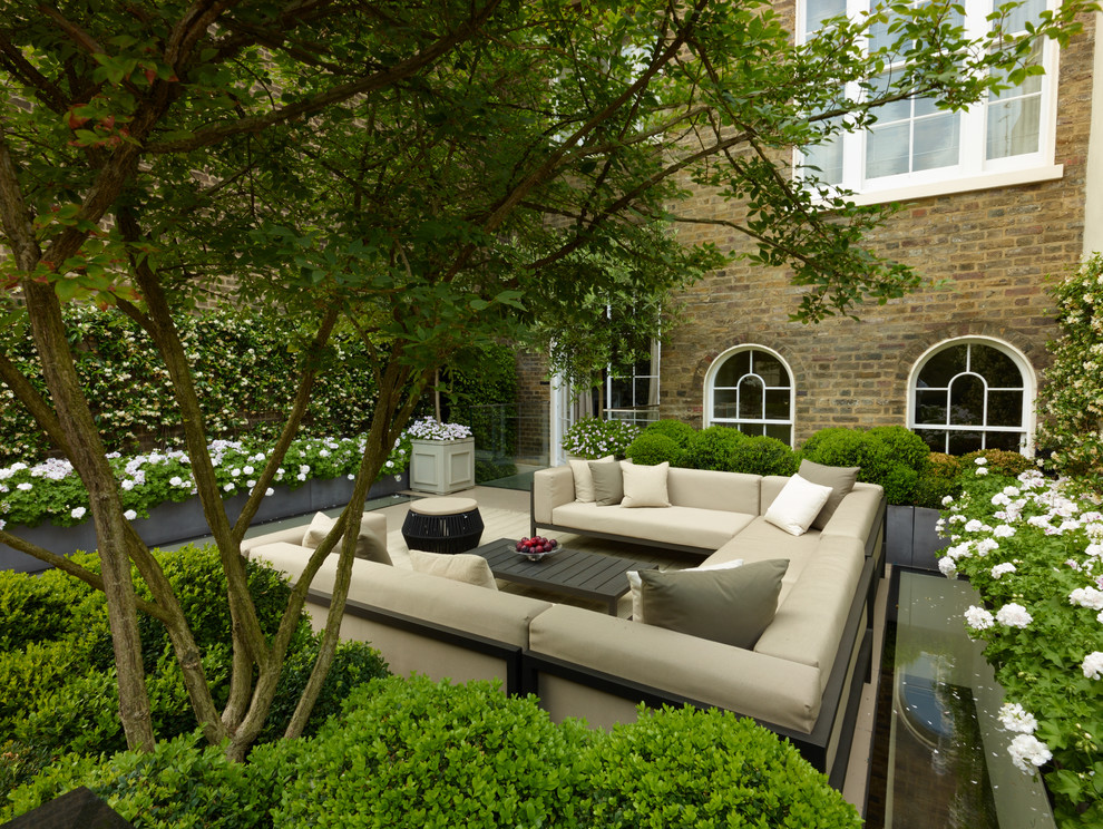 Design ideas for a mid-sized transitional patio in London.