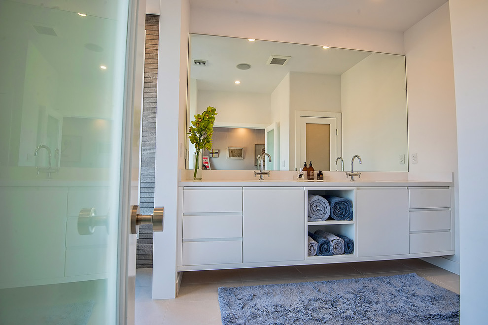 This is an example of a mid-sized contemporary master bathroom in Los Angeles with white cabinets, a freestanding tub, an open shower, a one-piece toilet, gray tile, porcelain tile, grey walls, porcelain floors, an undermount sink and engineered quartz benchtops.