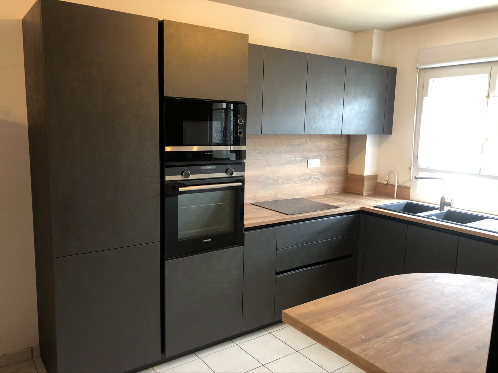 Design ideas for a mid-sized modern u-shaped separate kitchen in Lyon with a double-bowl sink, black cabinets, wood benchtops, timber splashback, black appliances, ceramic floors, no island and white floor.