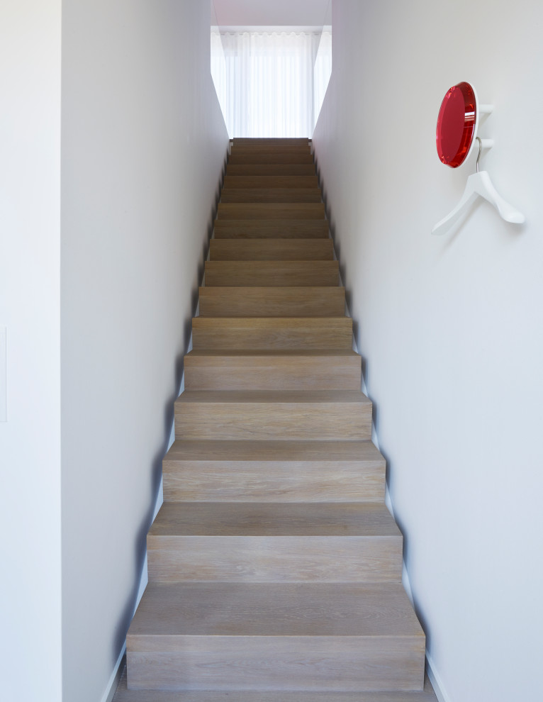 Imagen de escalera actual de tamaño medio con escalones de madera, contrahuellas de madera y barandilla de vidrio
