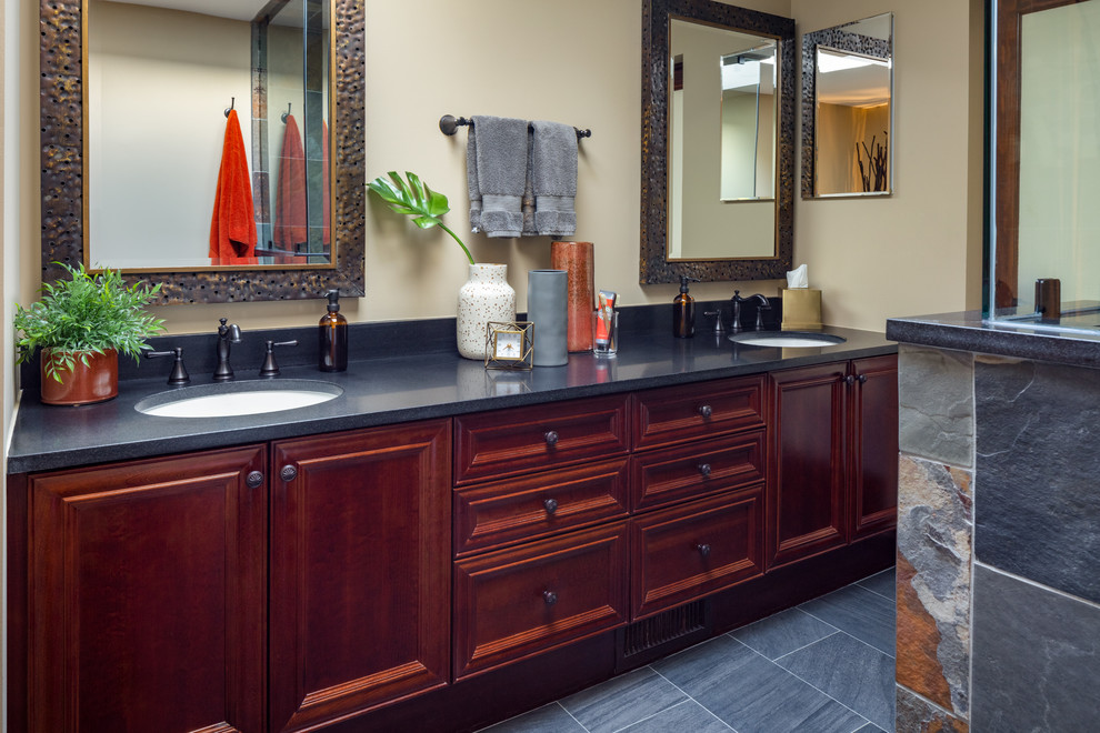 This is an example of a mid-sized country master bathroom in Other with dark wood cabinets, beige walls, slate floors, an undermount sink, granite benchtops, grey floor and blue benchtops.