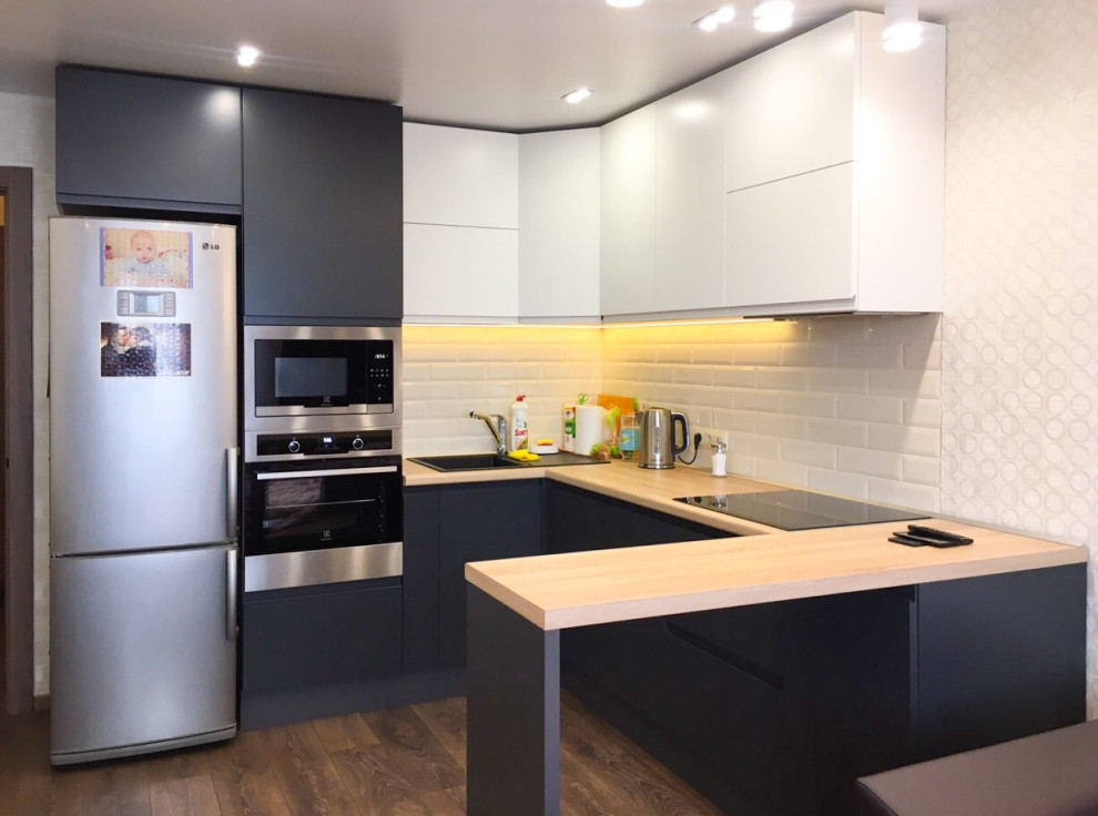 Design ideas for a small modern u-shaped open plan kitchen in Other with a drop-in sink, flat-panel cabinets, grey cabinets, wood benchtops, white splashback, ceramic splashback, stainless steel appliances, laminate floors, a peninsula, brown floor, beige benchtop and coffered.