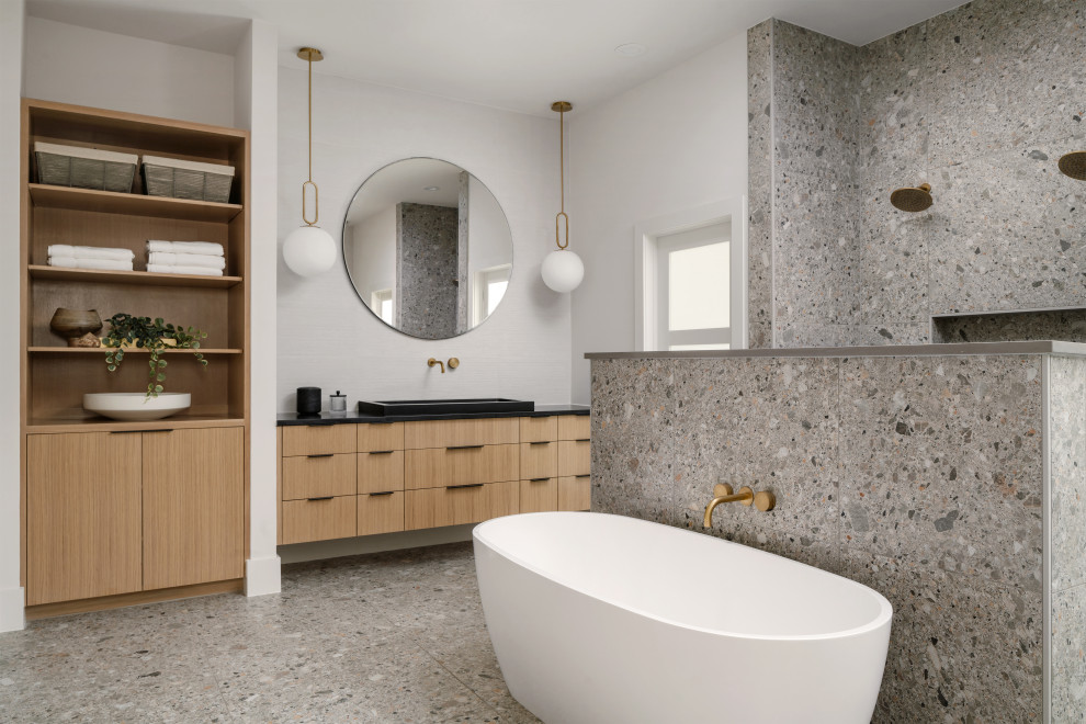 Inspiration for a contemporary master bathroom in Austin with flat-panel cabinets, medium wood cabinets, a freestanding tub, a double shower, gray tile, multi-coloured tile, white tile, terrazzo floors, a drop-in sink, engineered quartz benchtops, multi-coloured floor, an open shower, black benchtops, a single vanity and a floating vanity.