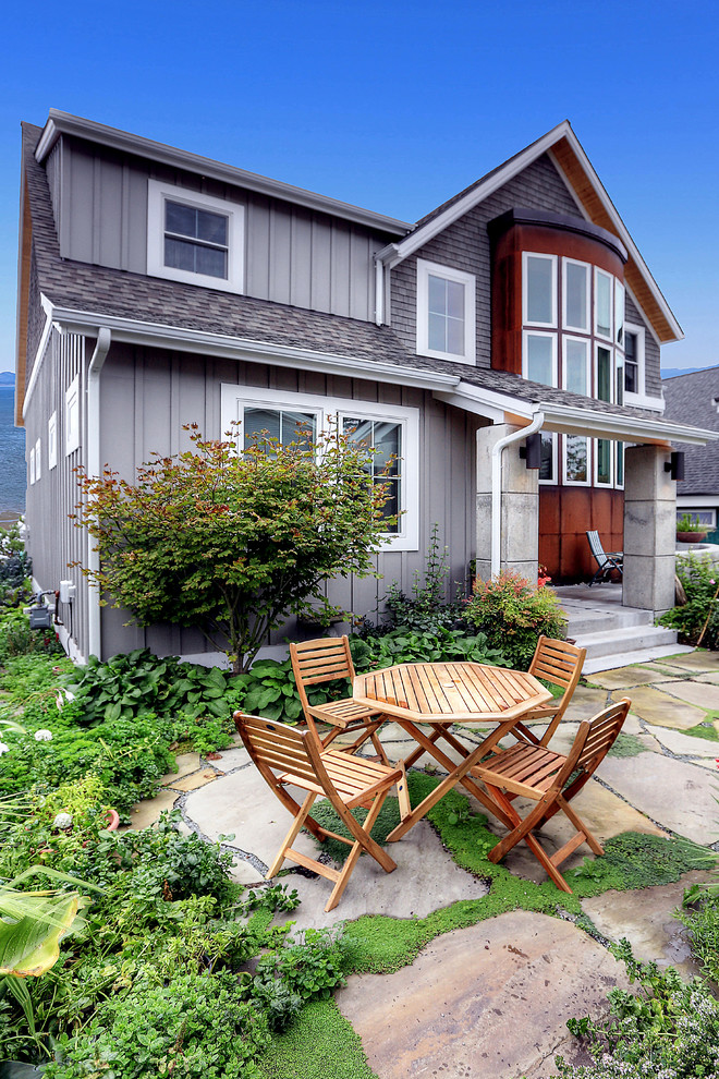 This is an example of a mid-sized beach style front yard patio in Seattle with natural stone pavers and no cover.