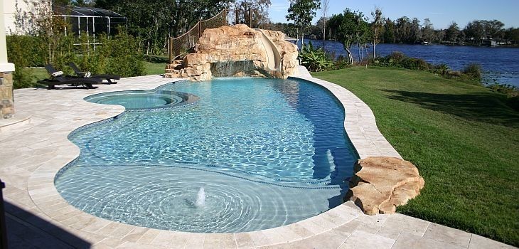 Photo of a mid-sized beach style backyard round pool in Orlando with a water slide and brick pavers.