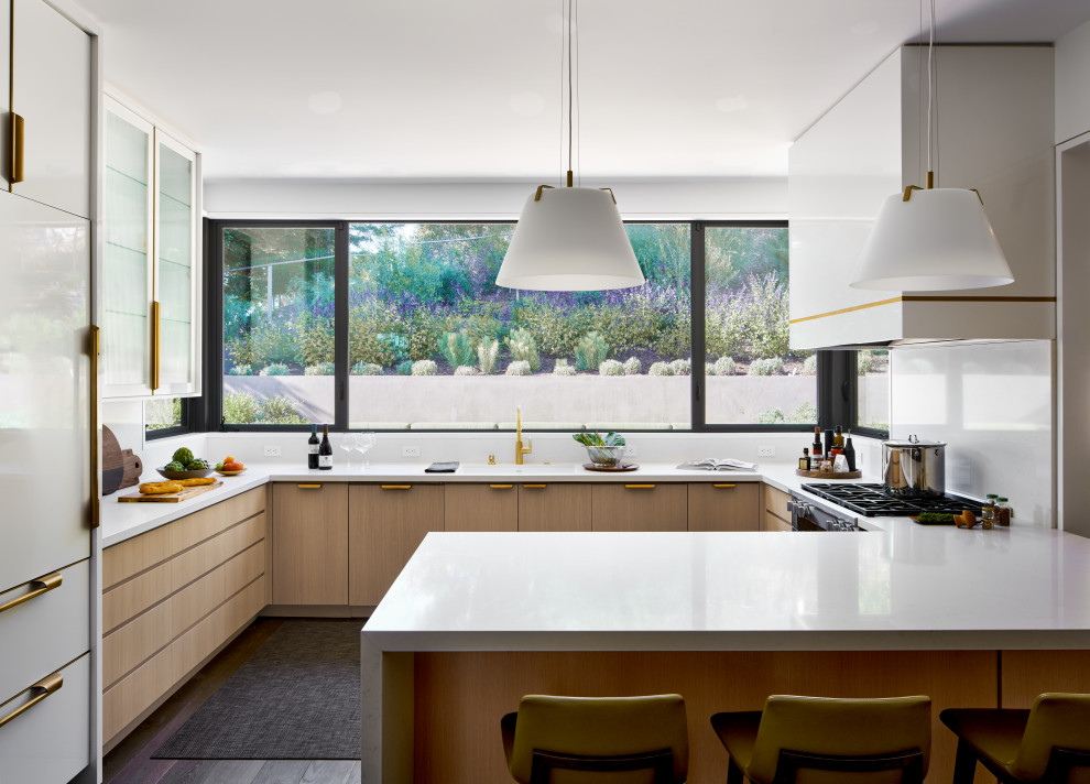 Inspiration for a large contemporary u-shaped kitchen/diner in San Francisco with a single-bowl sink, flat-panel cabinets, light wood cabinets, engineered stone countertops, white splashback, engineered quartz splashback, stainless steel appliances, dark hardwood flooring, an island, brown floors and white worktops.