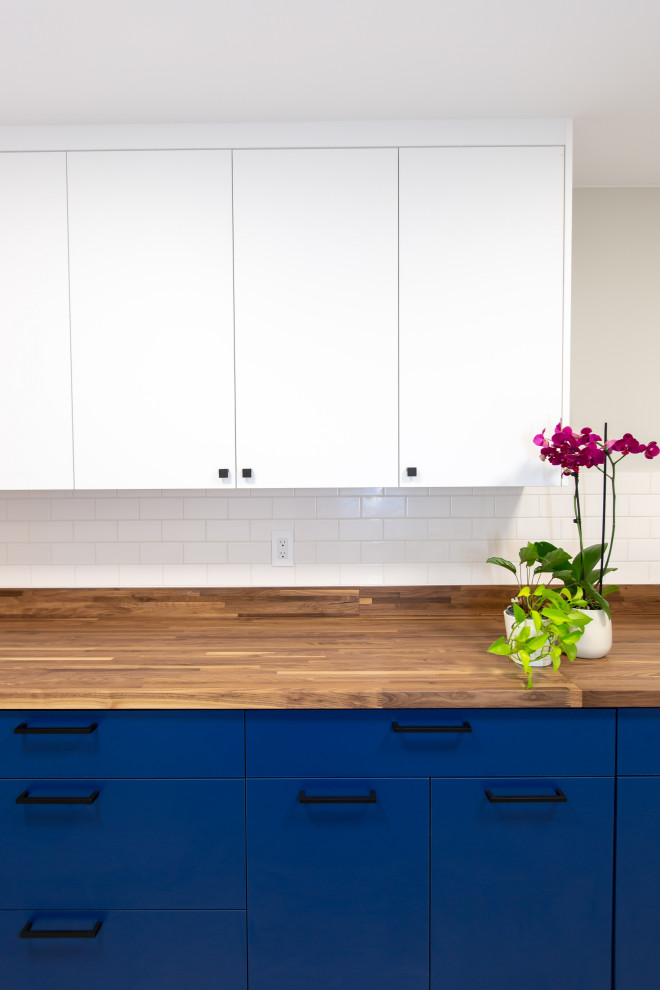 Mid-sized contemporary galley dedicated laundry room in Seattle with flat-panel cabinets and blue cabinets.