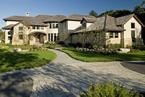 Design ideas for an expansive contemporary two-storey beige exterior in Chicago with stone veneer and a hip roof.