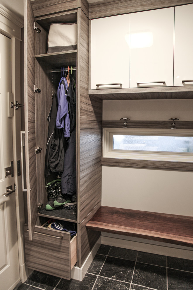 This is an example of a mid-sized transitional l-shaped utility room in Calgary with an utility sink, flat-panel cabinets, grey cabinets, quartz benchtops, beige walls, slate floors and a side-by-side washer and dryer.
