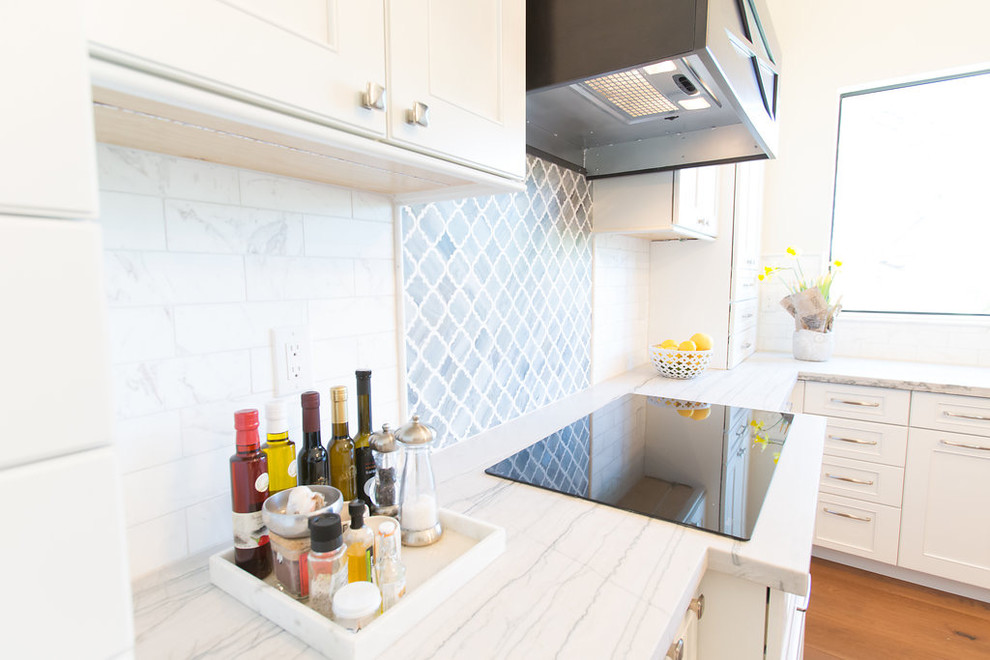 Open concept kitchen - large transitional l-shaped medium tone wood floor open concept kitchen idea in Phoenix with an undermount sink, shaker cabinets, white cabinets, quartzite countertops, marble backsplash, stainless steel appliances and an island