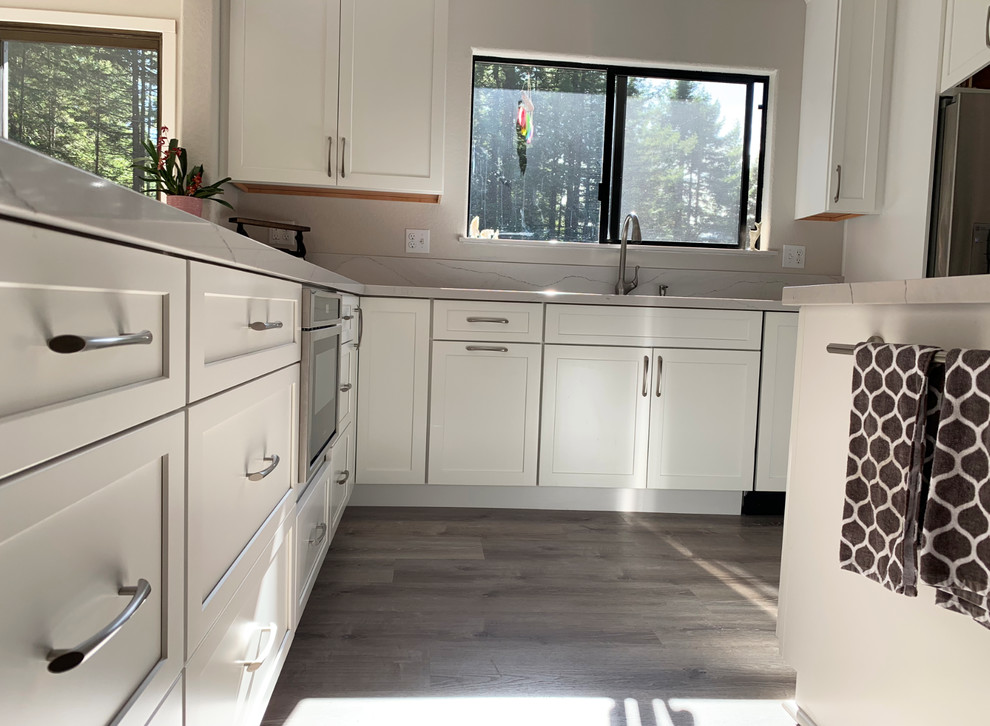 Eat-in kitchen - rustic beige floor eat-in kitchen idea with quartz countertops, stainless steel appliances and white countertops