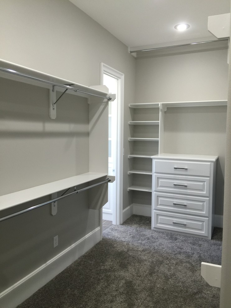 Photo of a mid-sized transitional gender-neutral walk-in wardrobe in Orange County with open cabinets, white cabinets, carpet and grey floor.