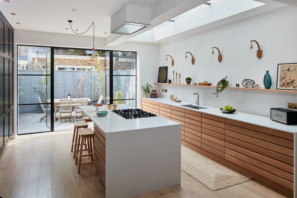 Medium sized contemporary open plan kitchen in London with composite countertops and an island.