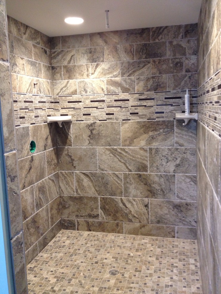 This is an example of a mid-sized mediterranean master bathroom in Portland Maine with an open shower, multi-coloured tile, stone tile, multi-coloured walls and ceramic floors.