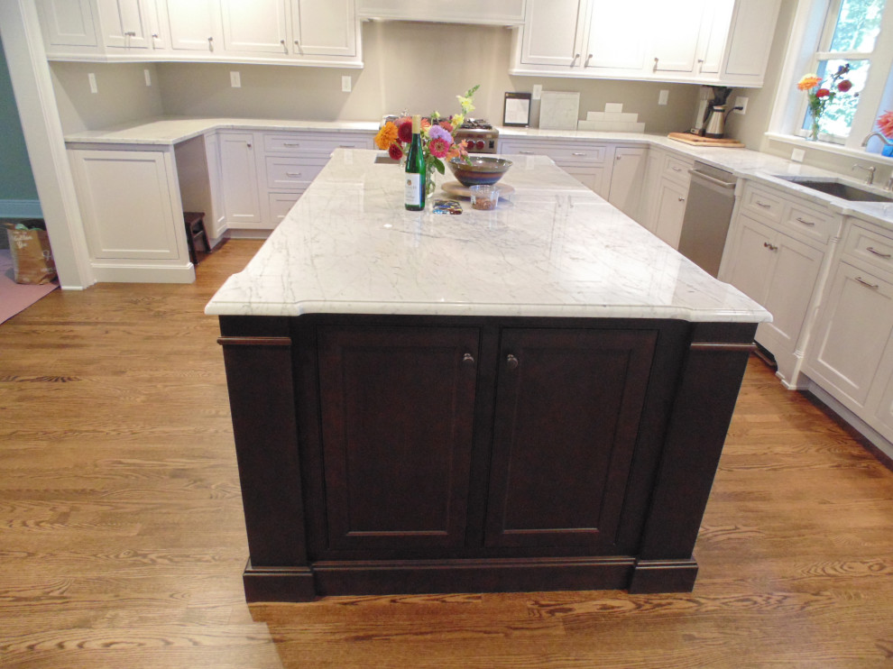 Eat-in kitchen - large transitional u-shaped medium tone wood floor and brown floor eat-in kitchen idea with an undermount sink, flat-panel cabinets, white cabinets, marble countertops, white backsplash, subway tile backsplash, stainless steel appliances, an island and white countertops
