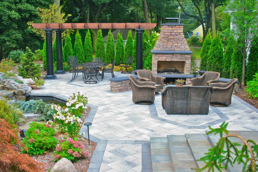 Photo of a large arts and crafts backyard patio in Grand Rapids with a fire feature, tile and a pergola.