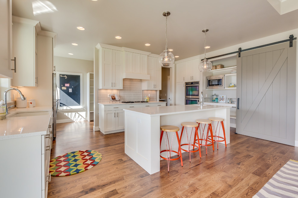 Eat-in kitchen - large transitional light wood floor eat-in kitchen idea in Boise with shaker cabinets, white cabinets, quartzite countertops, stainless steel appliances and an island