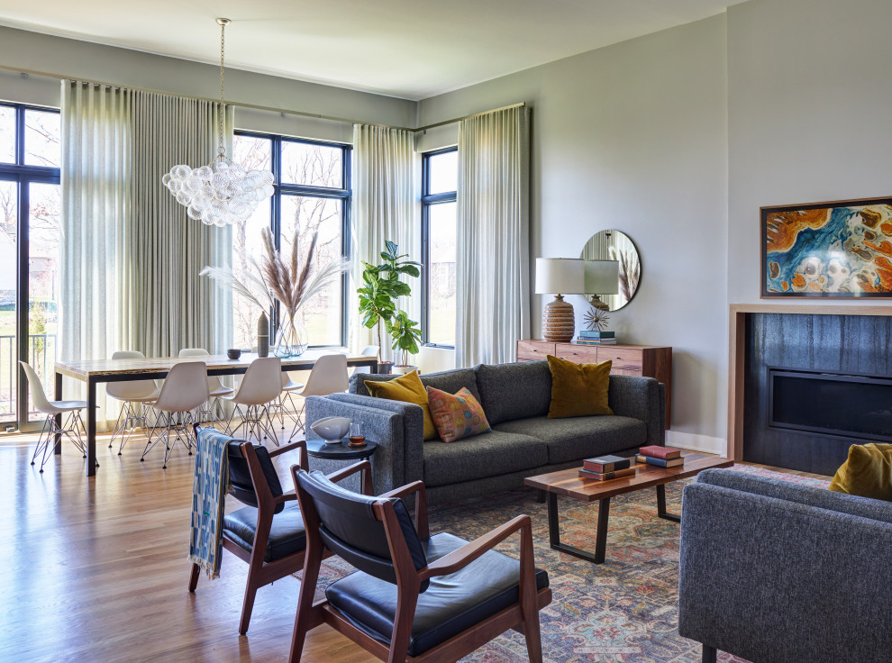 Retro Wohnzimmer mit grauer Wandfarbe, hellem Holzboden, Kamin und Kaminumrandung aus Metall in Chicago