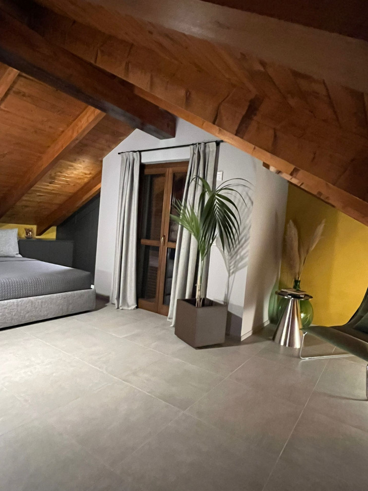 Ispirazione per un'In mansarda camera degli ospiti moderna di medie dimensioni con pareti gialle, pavimento in gres porcellanato, pavimento grigio e travi a vista