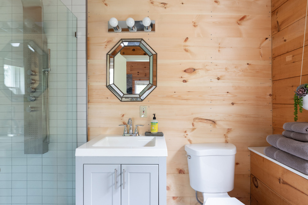 На фото: маленькая ванная комната в стиле лофт с фасадами с утопленной филенкой, серыми фасадами, душем в нише, раздельным унитазом, серой плиткой, плиткой кабанчик, белыми стенами, полом из сланца, душевой кабиной, монолитной раковиной, столешницей из искусственного камня, черным полом, открытым душем, белой столешницей, тумбой под одну раковину, напольной тумбой и деревянными стенами для на участке и в саду