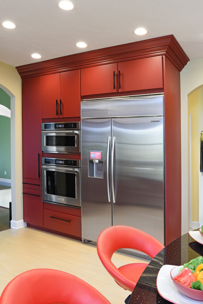 Enclosed kitchen - large transitional porcelain tile and beige floor enclosed kitchen idea with an undermount sink, flat-panel cabinets, red cabinets, granite countertops, beige backsplash, travertine backsplash, stainless steel appliances and an island