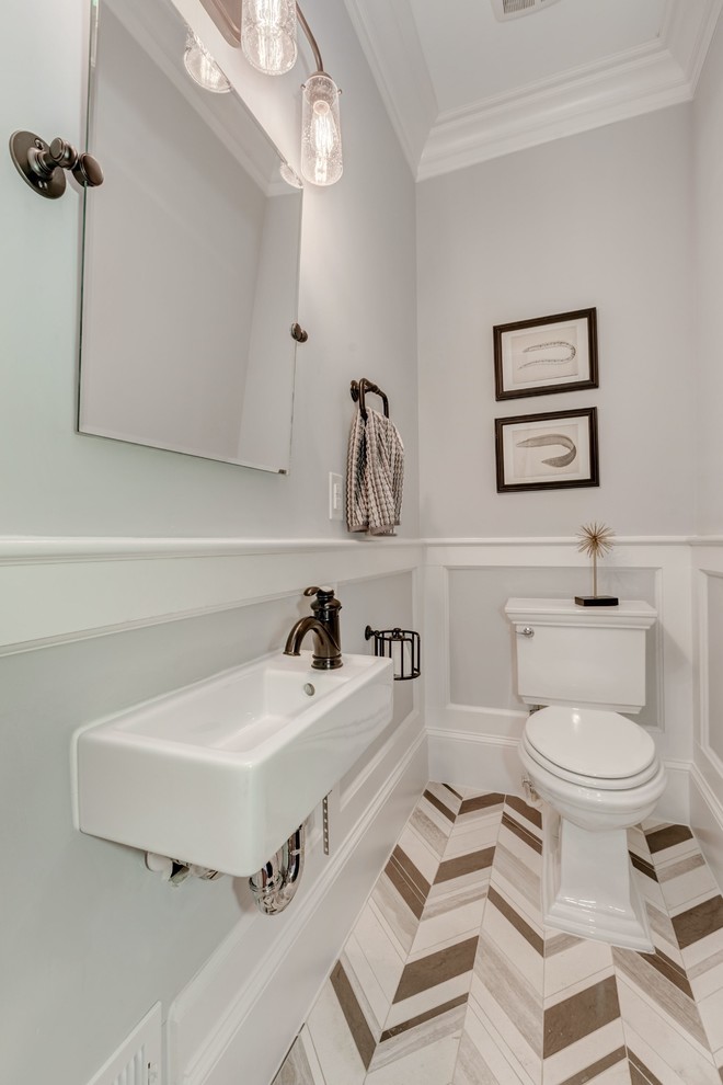 Mid-sized transitional powder room in DC Metro with a two-piece toilet, multi-coloured tile, stone tile, grey walls, limestone floors and a wall-mount sink.