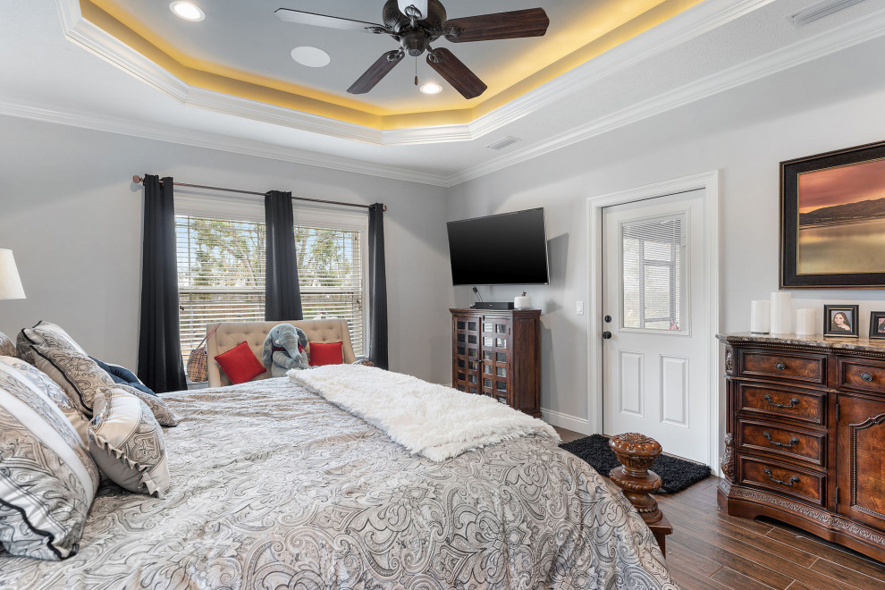 Mid-sized traditional master bedroom in Other with grey walls, porcelain floors and brown floor.