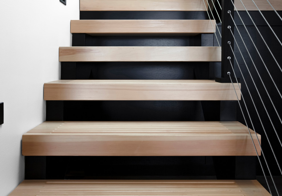На фото: п-образная лестница среднего размера в стиле модернизм с деревянными ступенями и перилами из тросов без подступенок