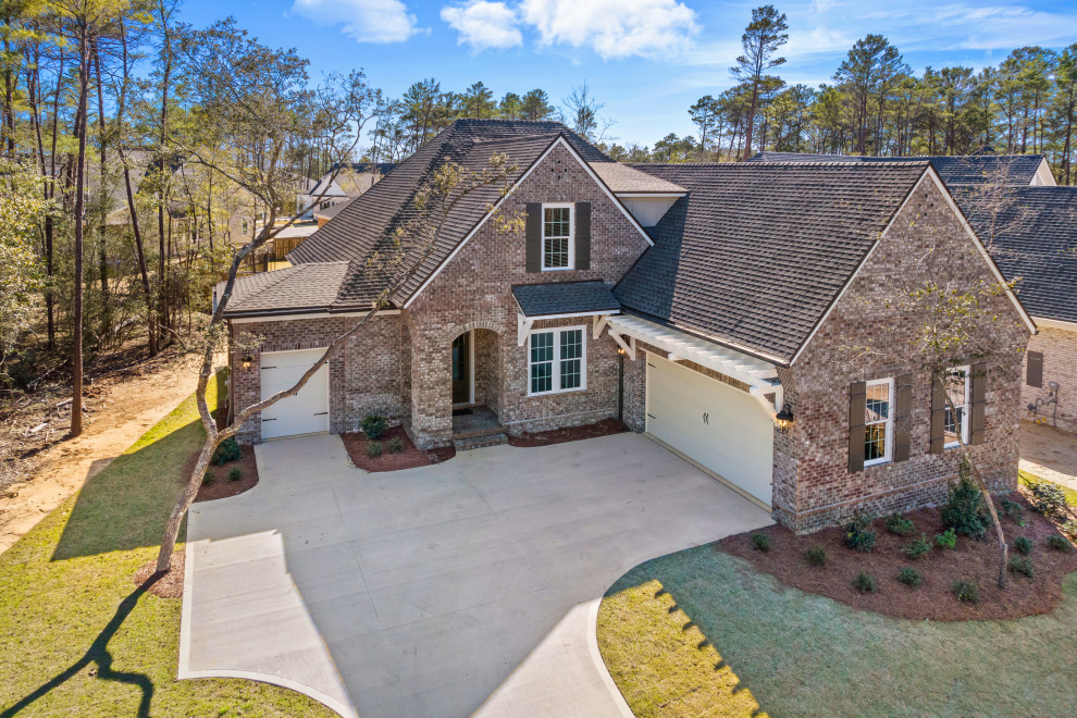 Transitional brown two-story brick house exterior idea with a shingle roof