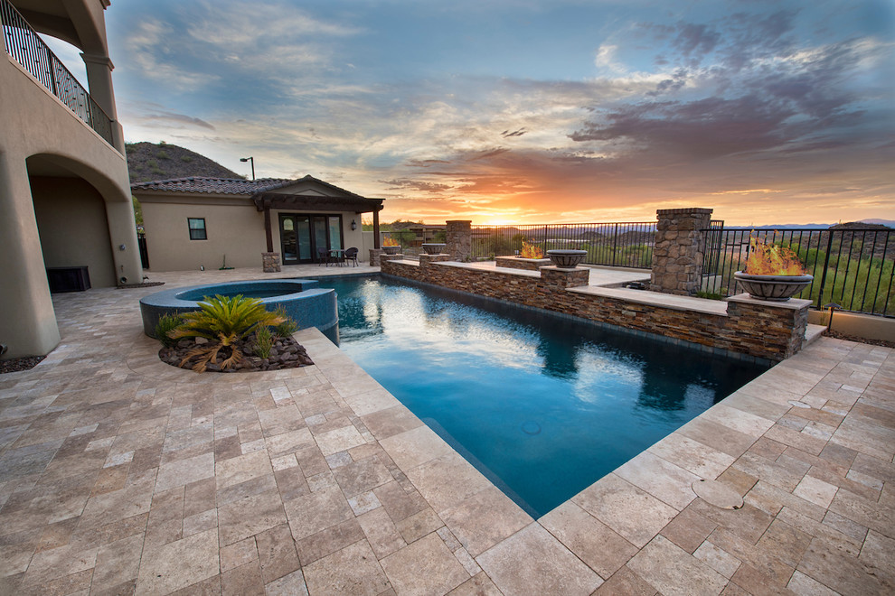 Large minimalist backyard stone and custom-shaped pool fountain photo in Phoenix