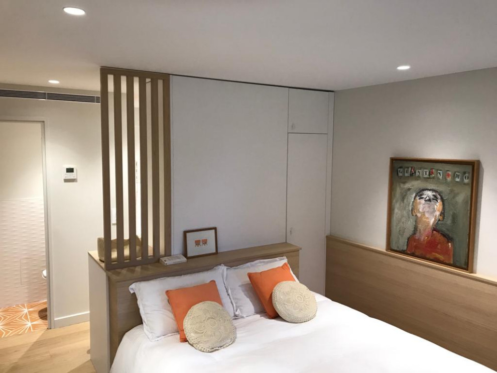 Contemporary bedroom in Nice with light hardwood floors and beige floor.