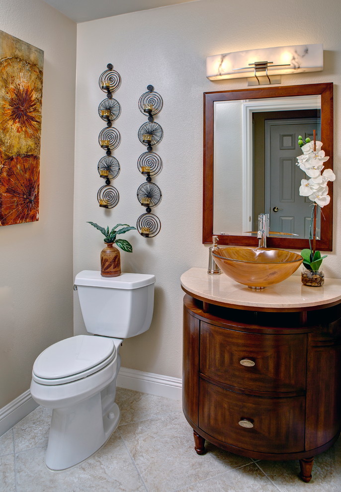 Traditional powder room in Las Vegas with a vessel sink, flat-panel cabinets, dark wood cabinets, granite benchtops, a two-piece toilet, beige walls and porcelain floors.