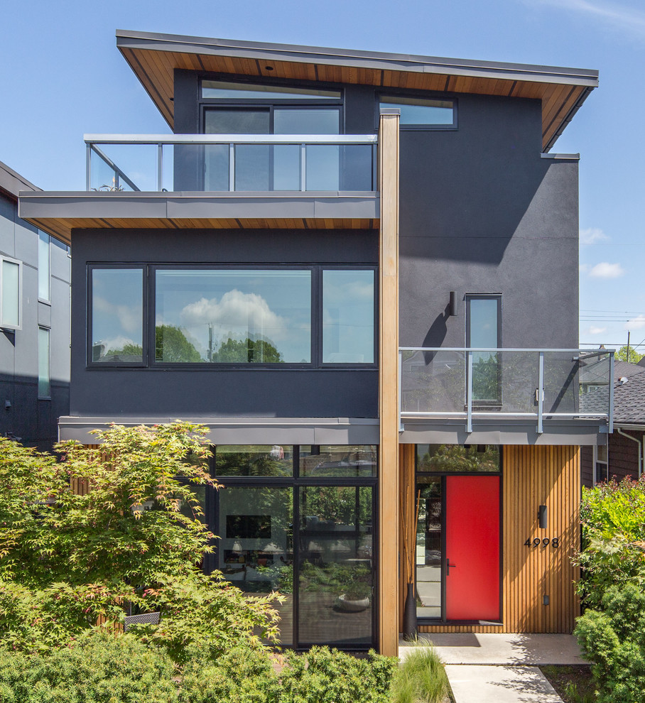Photo of a mid-sized contemporary three-storey grey house exterior in Vancouver with a shed roof and mixed siding.
