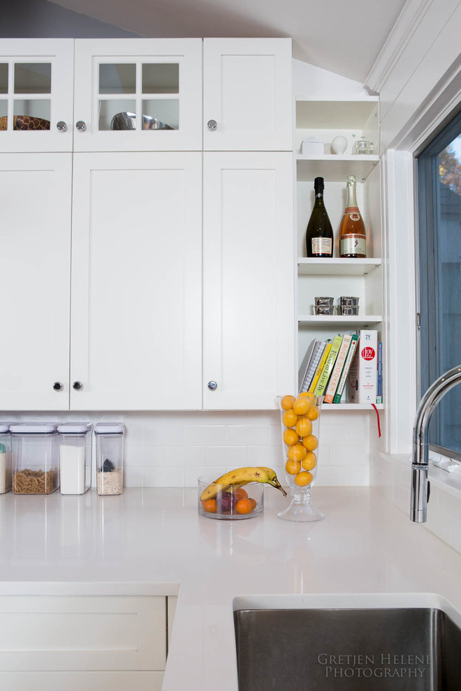 Eat-in kitchen - transitional eat-in kitchen idea with shaker cabinets, white cabinets, an undermount sink, quartz countertops, white backsplash, subway tile backsplash, stainless steel appliances and an island