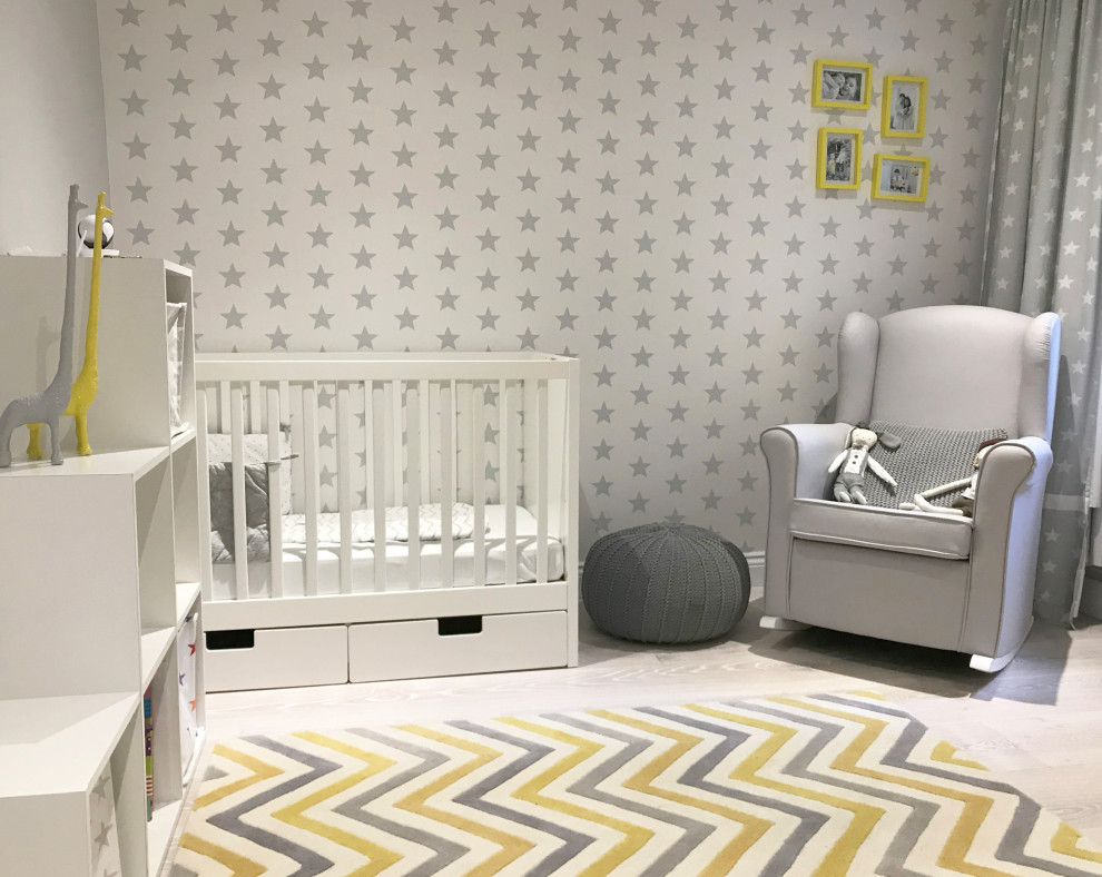 Foto di una piccola cameretta per neonato design con pareti grigie, parquet chiaro, pavimento grigio e carta da parati