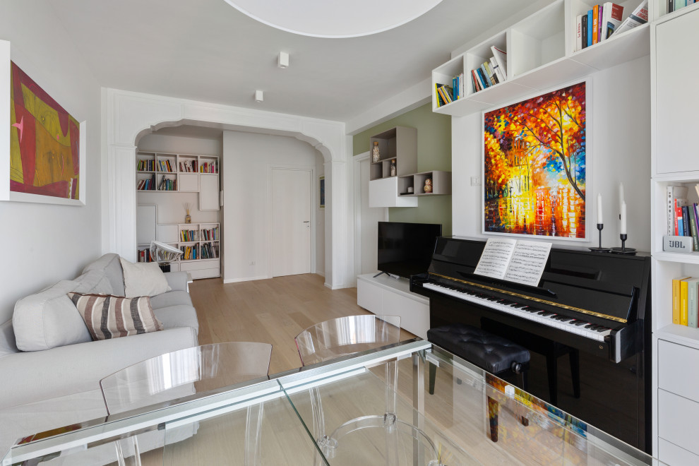 Foto på ett funkis vardagsrum, med ett musikrum, gröna väggar, ljust trägolv, en fristående TV och beiget golv