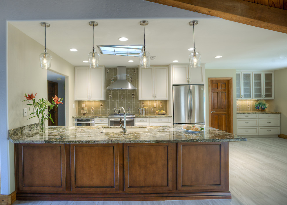 Eat-in kitchen - large transitional galley porcelain tile eat-in kitchen idea in Phoenix with an undermount sink, shaker cabinets, white cabinets, granite countertops, green backsplash, glass tile backsplash, stainless steel appliances and an island