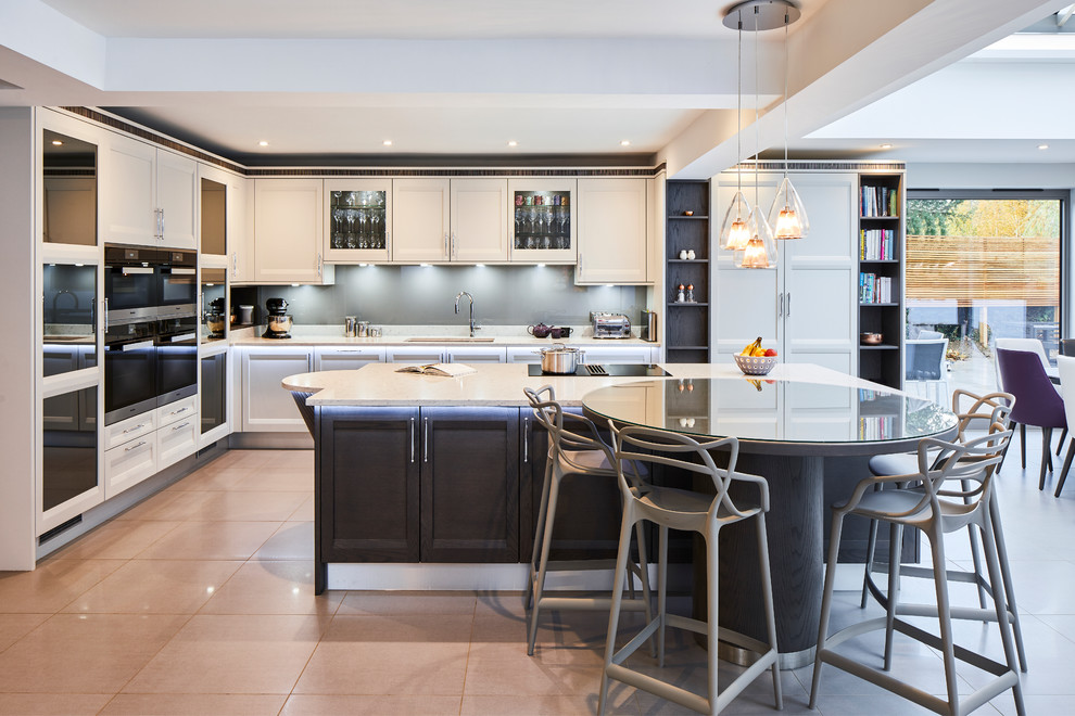 This is an example of a mid-sized contemporary l-shaped open plan kitchen in Surrey with black splashback, black appliances, with island, beige benchtop, an undermount sink, recessed-panel cabinets, beige cabinets and beige floor.