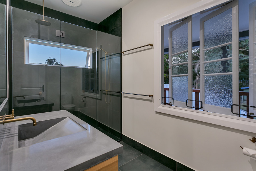 Mid-sized master bathroom in Cairns with light wood cabinets, a double shower, white tile, ceramic floors, stainless steel benchtops, grey floor and a hinged shower door.