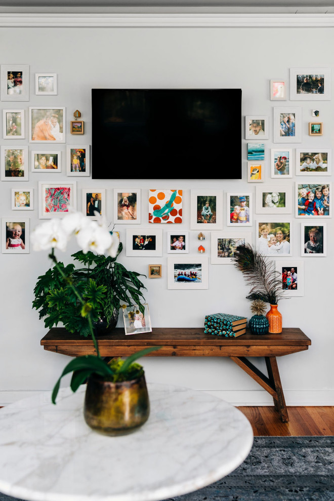 Immagine di un soggiorno minimalista di medie dimensioni e aperto con pareti bianche, parquet chiaro, TV a parete, pavimento marrone e soffitto a volta