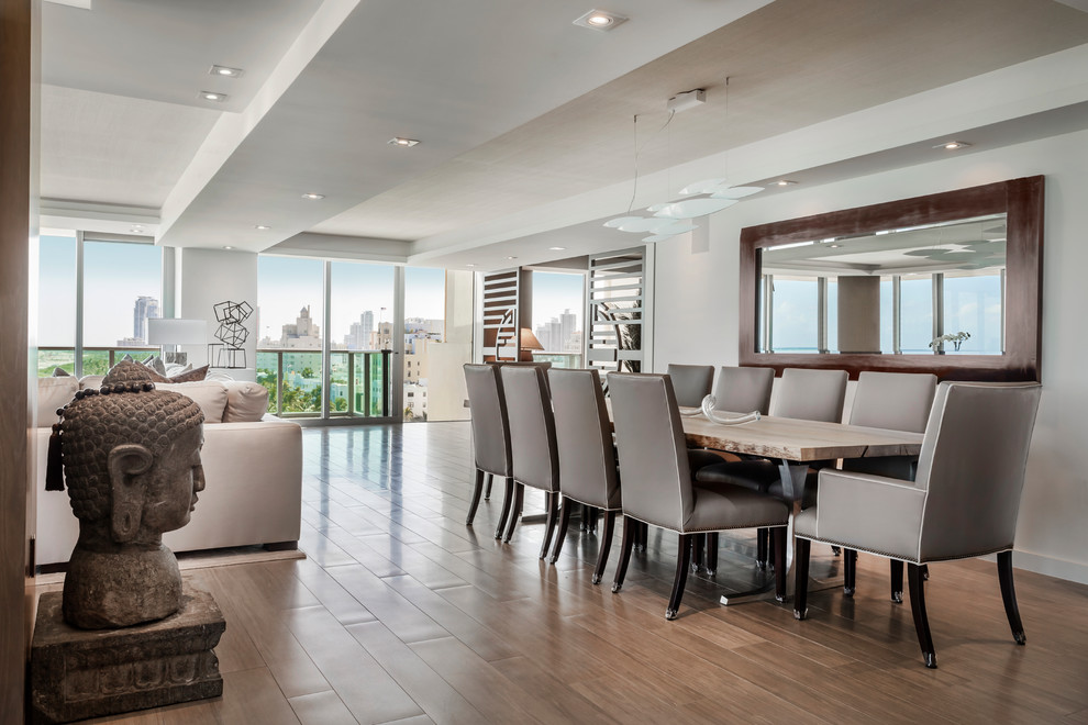 Photo of a contemporary dining room in Los Angeles with white walls, medium hardwood floors and brown floor.
