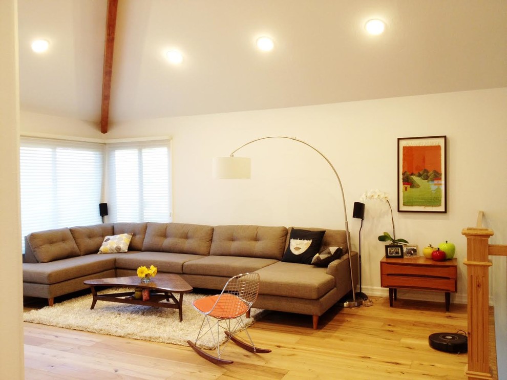 This is an example of a mid-sized midcentury enclosed family room in Other with white walls, light hardwood floors and brown floor.