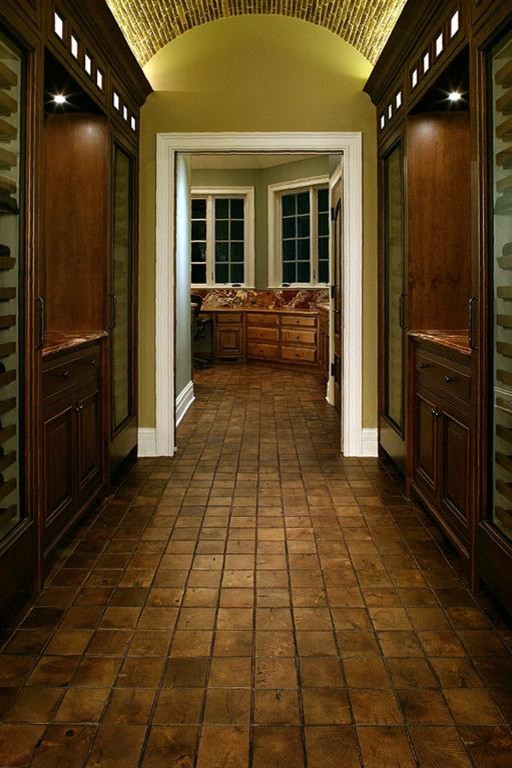 This is an example of an expansive arts and crafts wine cellar in Indianapolis with medium hardwood floors and display racks.