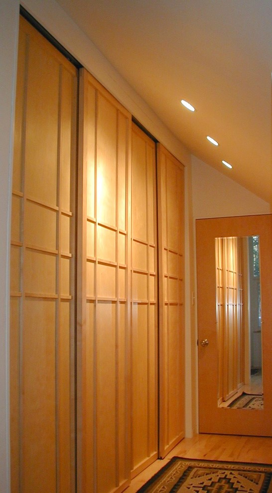 This is an example of a midcentury storage and wardrobe in Boston with light hardwood floors.